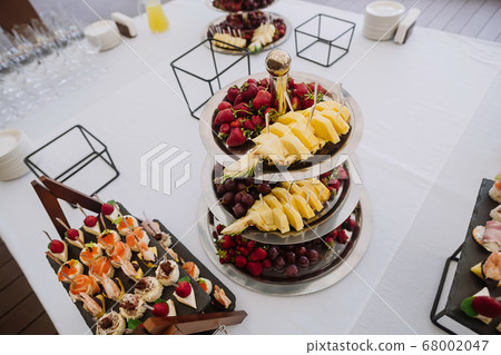 Different fruits and light snack on tray 68002047