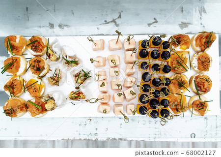 Different light snack on wooden tray near the bar Different light snack on wooden tray near the bar 68002127