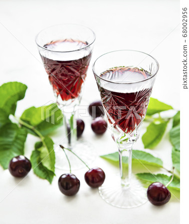 Cherry liqueur in a glass and fresh fruits Cherry liqueur in a glass and fresh fruits 68002956