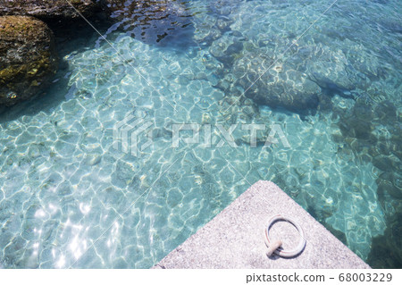 閃閃發光的夏天海和環掛在碼頭上的繩索 閃閃發光的夏天海和環掛在碼頭上的繩索 68003229