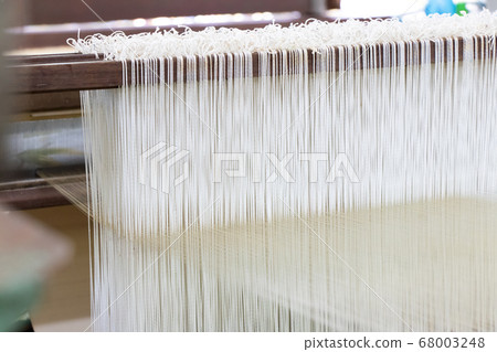 Closed up of loom with white thread background 68003248