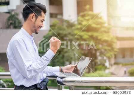 Young businessman excited raise hand up be glad Young businessman excited raise hand up be glad 68003928