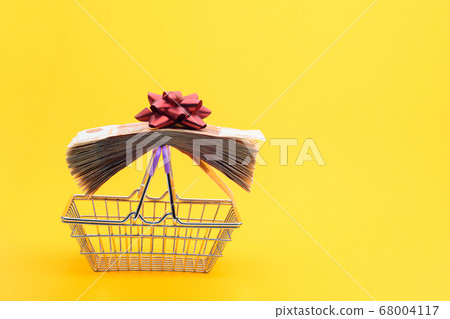 On the handles of the grocery cart lies a bundle 68004117