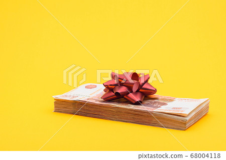 On the bundle of five thousandth bills lies a red 68004118