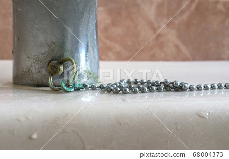 Calcium deposits on chain bathroom sink stopper Calcium deposits on chain bathroom sink stopper 68004373