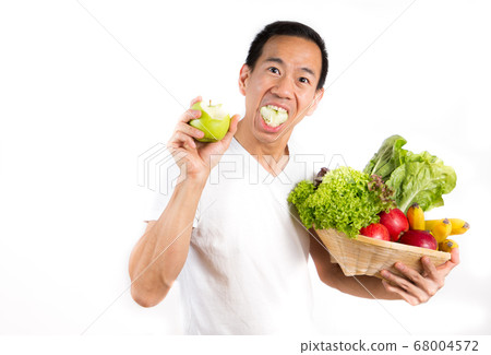 A picture of an Asian man eating an apple A picture of an Asian man eating an apple 68004572