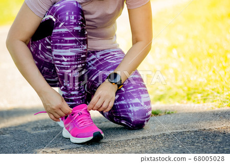 Running shoe color pink - women tying shoelaces. Running shoe color pink - women tying shoelaces. 68005028