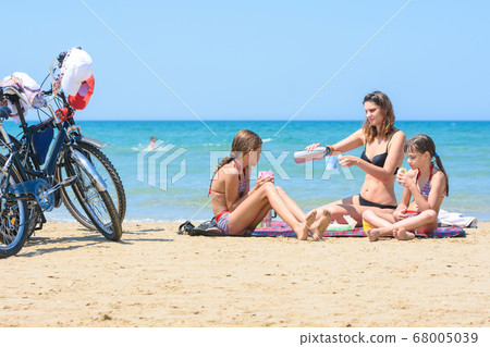 Children and mother eat while sitting on the Children and mother eat while sitting on the 68005039
