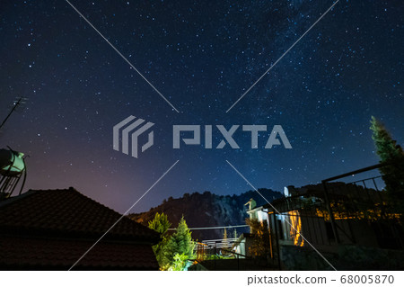 Stars and Milky Way over the forest and a house at Stars and Milky Way over the forest and a house at 68005870