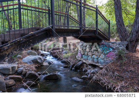 Bridge over smooth flowing water stream at the 68005871