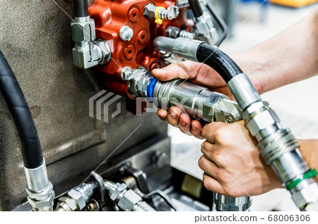 Industrial worker assembles agricultural equipment at plant Industrial worker assembles agricultural equipment at plant 68006306