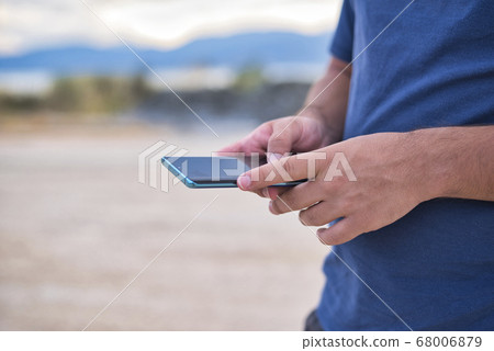 Teenage Boy Using Phone In Urban Setting 68006879