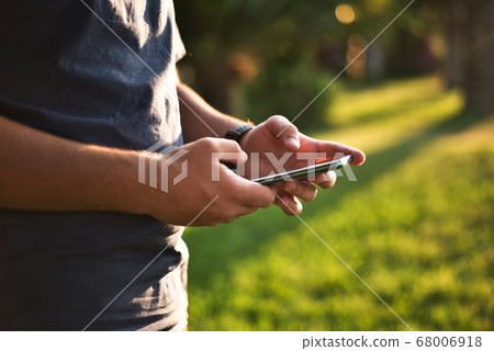 Teenage Boy Using Phone In Urban Setting 68006918