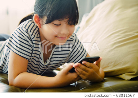 Little girl using smartphone at home Little girl using smartphone at home 68011567