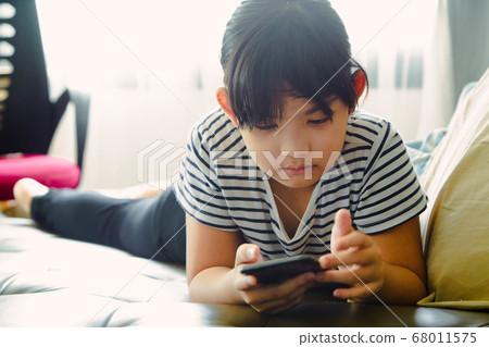 Little girl using smartphone at home 68011575