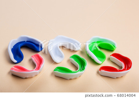 mouth guards for boxing or karate lie on a beige 68014004