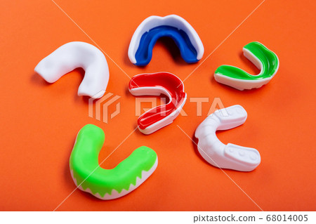 Lots of boxing protective mouthguards on orange 68014005