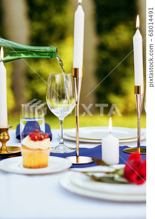 Table setting, wine is poured into a wineglass 68014491