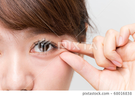 A woman who pinches the corners of the eyes. 68016838
