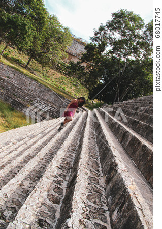Woman alone at the stairs of ancient Uxmal Pyramid in Merida, Yucatan, Mexico 68017745