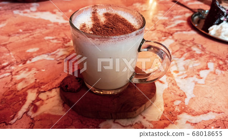 Turkish traditional winter drink salep with cinnemon powder into the glass cup on the marble table Turkish traditional winter drink salep with cinnemon powder into the glass cup on the marble table 68018655