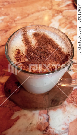 Turkish traditional winter drink salep with cinnemon powder into the glass cup on the marble table 68018657