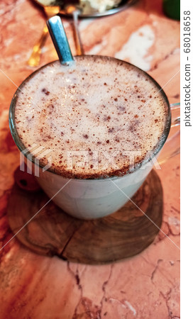 Turkish traditional winter drink salep with cinnemon powder into the glass cup on the marble table 68018658