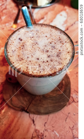 Turkish traditional winter drink salep with cinnemon powder into the glass cup on the marble table Turkish traditional winter drink salep with cinnemon powder into the glass cup on the marble table 68018659