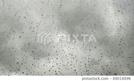 Raindrops on window view in rainy season in Turkey. Rain running down on window with cloudy sky blur light, grey color background Raindrops on window view in rainy season in Turkey. Rain running down on window with cloudy sky blur light, grey color background 68018896