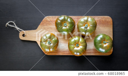 Black Krim organic tomatoes on a cutting board 68018965