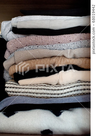 clothes neatly stacked in a closet 68019442