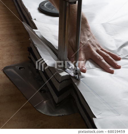 cloth cutting with an electric knife, male hand, cloth cutting with an electric knife, male hand, 68019459