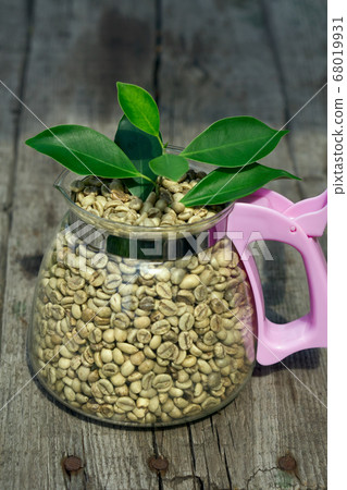 green coffee beans with glass pot and green leaves green coffee beans with glass pot and green leaves 68019931