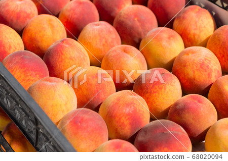 a lot of red ripe peaches lie in rows in boxes, a 68020094