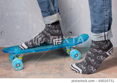 male legs in gray socks, on a blue skateboard, the male legs in gray socks, on a blue skateboard, the 68020732