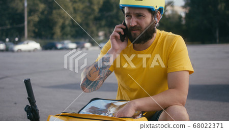 Delivery man searching in his backpack Delivery man searching in his backpack 68022371