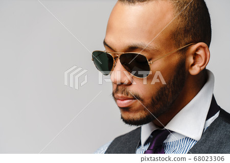 African-American businessmanman wearing glasses portrait over grey background African-American businessmanman wearing glasses portrait over grey background 68023306