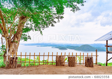 Natural chair made from wooden log for lookout point with resting . Beautiful scenery of nature with a large reservoir above the Srinagarind Dam at Rai Ya Yam view point in Kanchanaburi, Thailand. 68023358