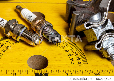 Motorcycle repair parts Spark plug and muffler clamp Background/image table photo Motorcycle repair parts Spark plug and muffler clamp Background/image table photo 68024592