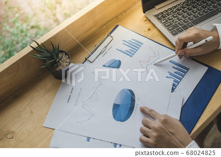 Business man holding a pen and point at the paper Business man holding a pen and point at the paper 68024825