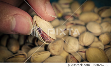 Seller is holding one of Pistachios over the full surface of it. Seller is holding one of Pistachios over the full surface of it. 68026299