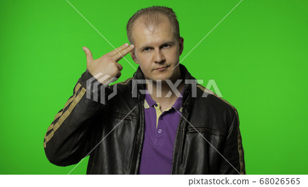 Man pointing finger pistol to head, showing suicide gesture, shooting himself with hand gun Man pointing finger pistol to head, showing suicide gesture, shooting himself with hand gun 68026565