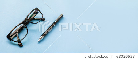 Close up of pen and glasses on blue background for mockup design modern lifestyle stationary concept. Blue office table with supplies. Modern office desk Workspace Working background. Close up of pen and glasses on blue background for mockup design modern lifestyle stationary concept. Blue office table with supplies. Modern office desk Workspace Working background. 68026638
