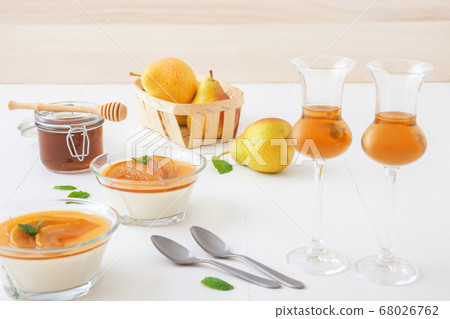 Panna cotta Italian traditional dessert with pears poached in rum and honey syrup. Panna cotta Italian traditional dessert with pears poached in rum and honey syrup. 68026762