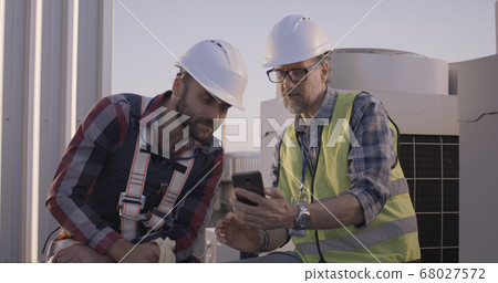 Engineers having a break on a cell tower Engineers having a break on a cell tower 68027572