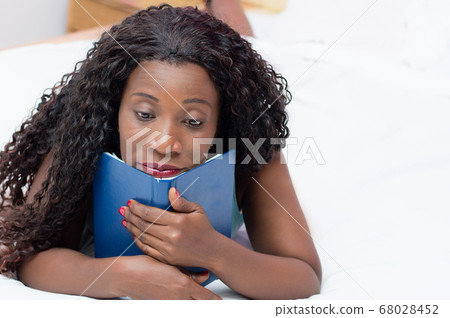 pensive young woman lying in bed 68028452