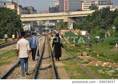 Dhaka, the capital of Bangladesh People walking along the streets and railroad tracks Muslim women in hijab 68029037