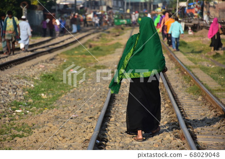 Bangladeshi people walking along the Dhaka railroad in the capital of Bangladesh Muslim woman wearing a green hijab Bangladeshi people walking along the Dhaka railroad in the capital of Bangladesh Muslim woman wearing a green hijab 68029048