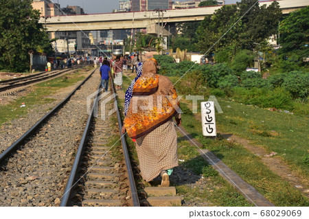 Dhaka, the capital city of Bangladesh, wearing a hijab, a Muslim woman walking along the railroad tracks Dhaka, the capital city of Bangladesh, wearing a hijab, a Muslim woman walking along the railroad tracks 68029069