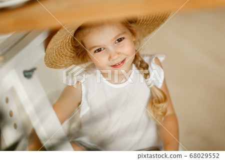 portrait of little girl in big straw hat. close up 68029552